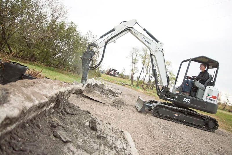 bobcat excavator with breaker attachent busting cement blocks