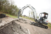 bobcat excavator with breaker attachent busting cement blocks