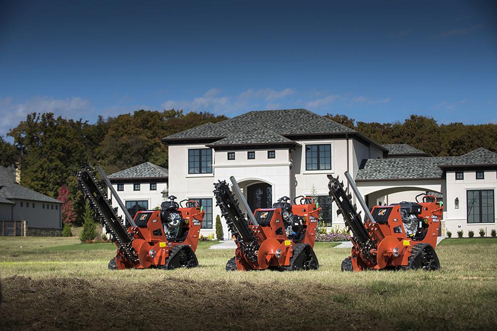 three ditch witch trench diggers in front of a house