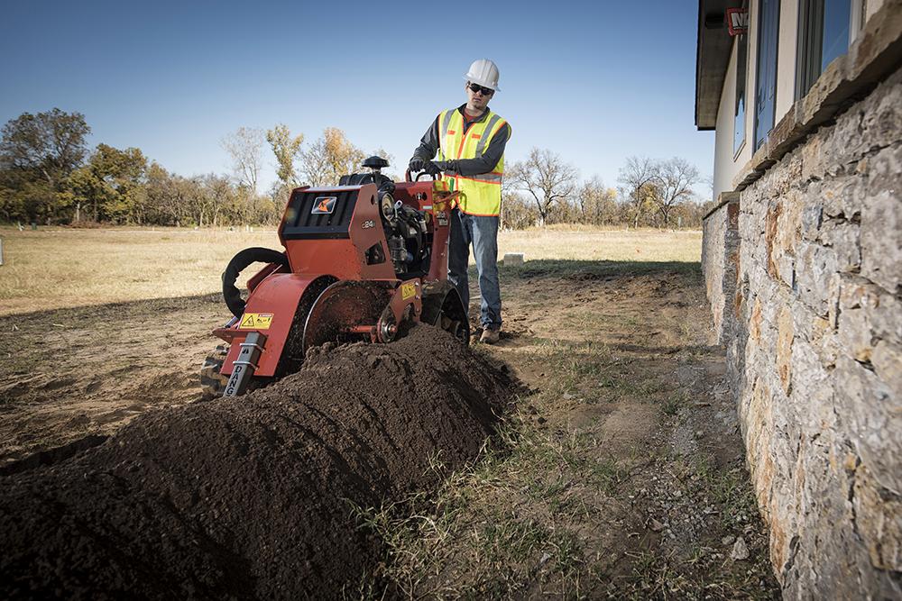 man using ditch witch trencher