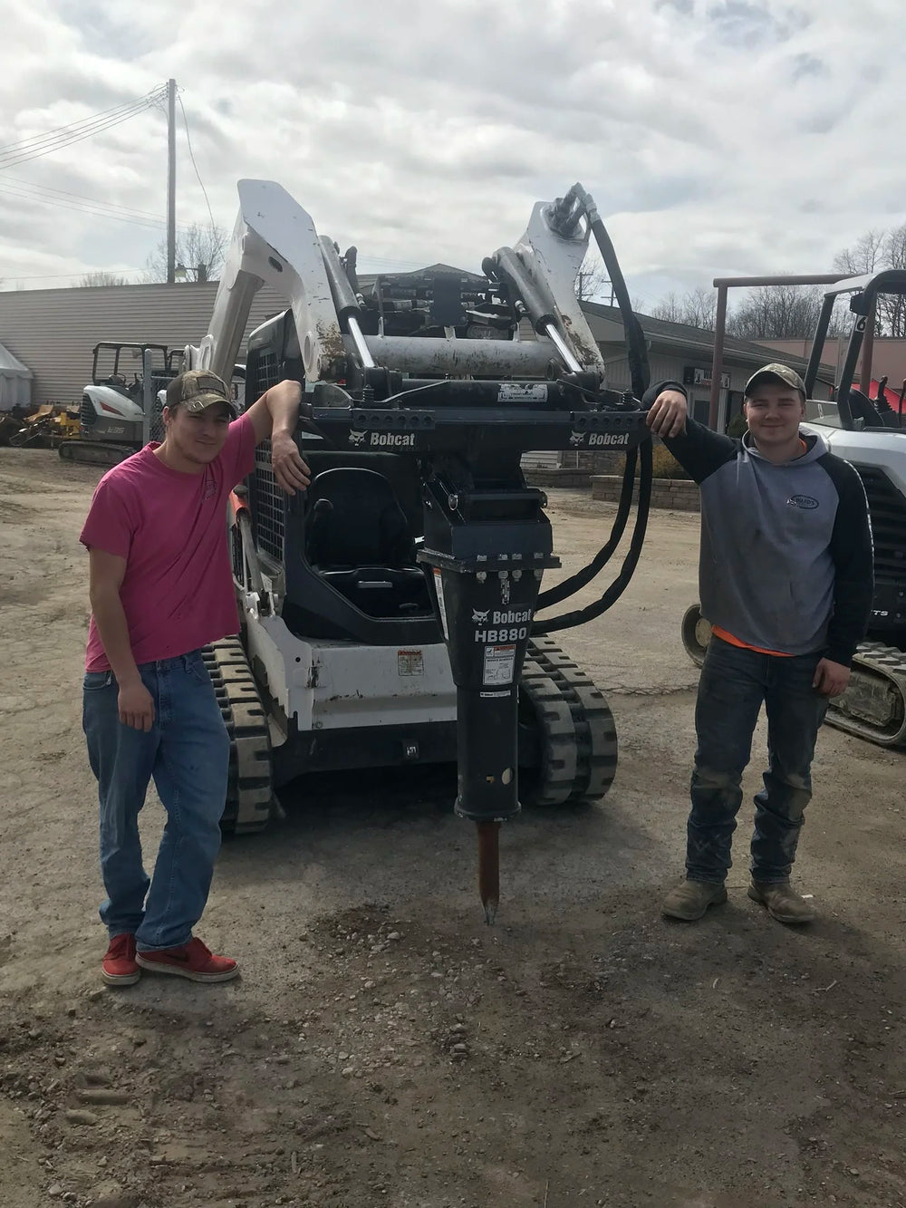 two men leaning on a hydraulic breaker machine