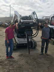 two men leaning on a hydraulic breaker machine