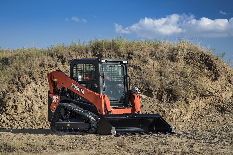 kubota skid loader in front of a pile of dirt