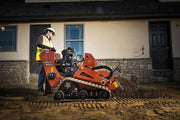 side view of ditch witch trencher being used