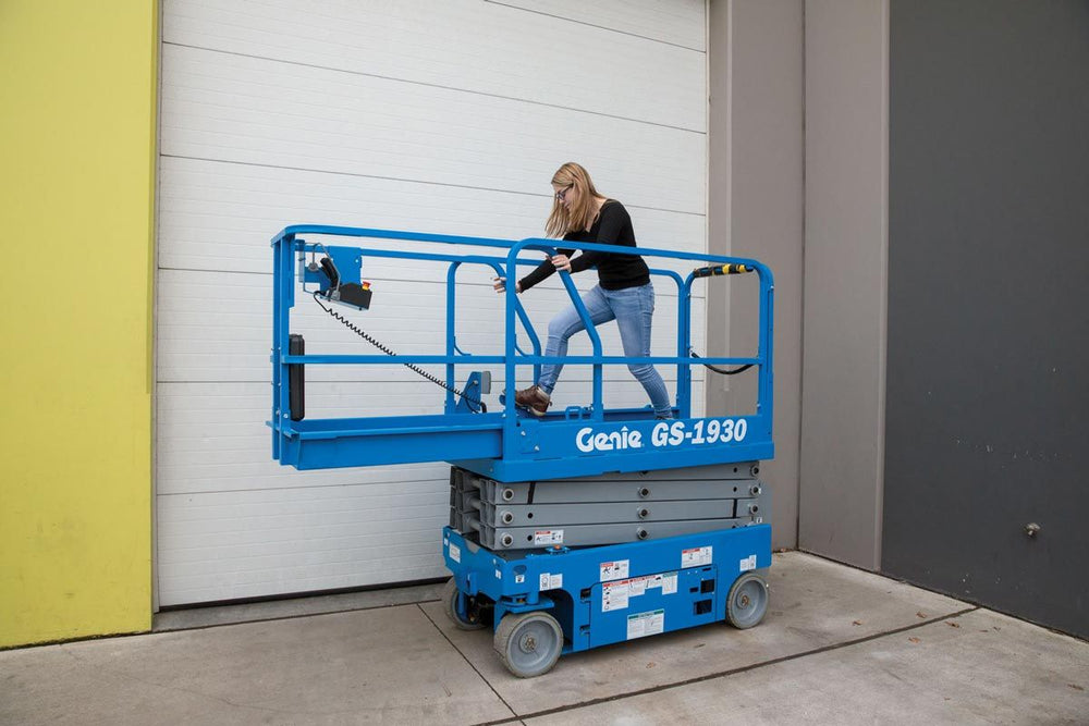 woman standing on platform of scissor lift