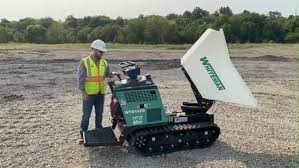 man standing next to cement buggy in field